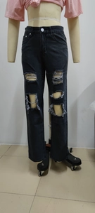 Detail shot of black distressed high-waisted wide-leg jeans with ripped knees and frayed edges