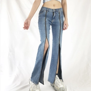Close-up of women's blue flared jeans featuring full-length front zippers and split leg detail