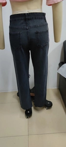 Detail view of high-waist dark grey wide-leg jeans with back pockets on mannequin