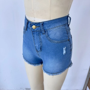 Detail view of high waist denim shorts with distressed rips and frayed raw hems