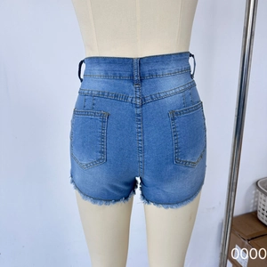 Detail view of high waist denim shorts with back pockets and frayed tassel hem details