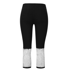 Détail du legging noir extensible avec une bordure en dentelle florale blanche aux jambes