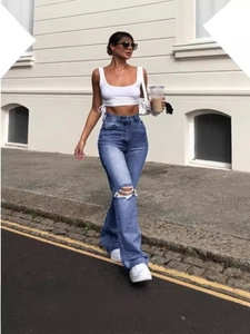 Jeans da donna a vita alta a gamba larga con strappi in lavaggio azzurro sulla modella
