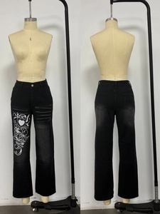 Détails du jean noir style urbain avec imprimés cœurs et délavages moustaches sur les cuisses