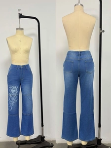 Détail de l'imprimé cœur tribal Y2K sur jean en denim bleu délavé devant et derrière