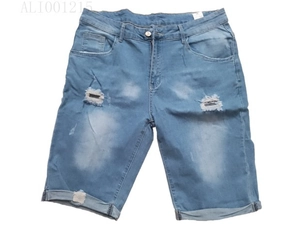 Dettaglio dei pantaloncini in denim azzurro con strappi consumati e risvolto sull'orlo