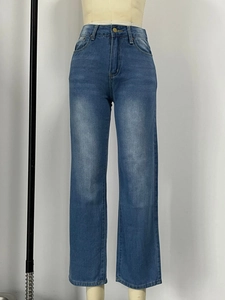 Close-up of high waist blue denim pants with retro wash finish and metallic button detail
