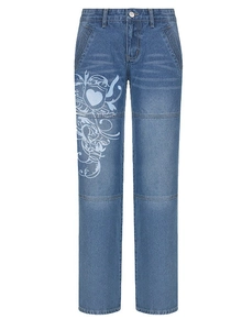 Détail d'un jean droit bleu avec imprimé graphique en forme de cœur vintage et texture lavée