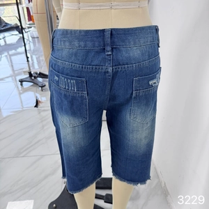 Detail view of washed blue denim shorts featuring frayed hems and vintage distressed pockets