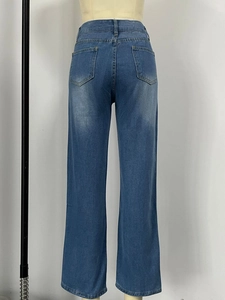 Detail view of high waist wide leg jeans with distressed back pockets and denim texture