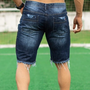 Slim fit men's distressed blue denim shorts with raw hem and faded wash finish