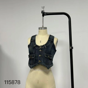 Detail view of dark blue washed denim vest with metallic buttons and flap pockets