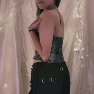 Vintage Denim-Korsett-Oberteil mit Schnallen und schwarze Cargohose mit Metallringen
