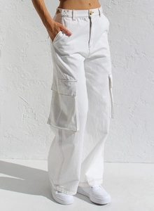 Détail du pantalon cargo blanc avec grandes poches latérales et coutures marron