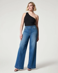 Detail view of high-waist dark blue wide-leg jeans with center seams and black heels