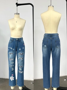 Detail of blue straight jeans with distressed ripped patches and floral leopard print