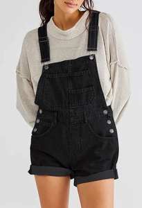 Vue détaillée de la salopette en jean noir avec boutons latéraux et ourlet fixe à revers