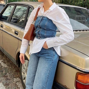 Nahaufnahme des Retro-Denim-Korsett-Tops mit Knöpfen über einem weißen Langarmhemd