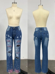 Detail of ripped jeans with leopard print patches and pink sequins on the hemline