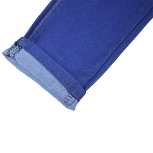 Detailed close-up of cuffed hem on dark blue slim fit denim jeans with yellow stitching