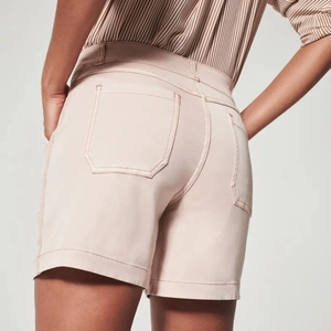 Detail view of pink slim-fit denim shorts featuring back pockets and tailored cut