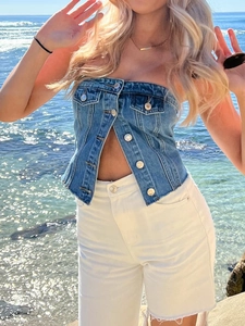 Detailaufnahme von blauem Denim-Korsett-Top mit Metallknöpfen und Taschen am Strand