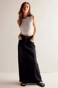 Detail of a black maxi denim skirt with side pockets and a stylish frayed hemline