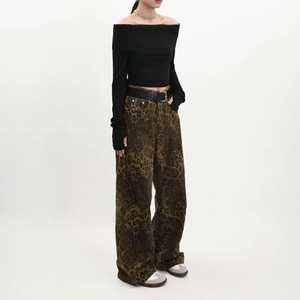 Détail du jean large taille haute à imprimé léopard avec une ceinture noire élégante