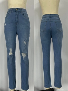 Détail de jean skinny taille haute avec genoux déchirés et ourlet brut bleu clair
