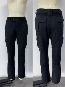 Detail of black motorcycle cargo pants showing accordion stretch panels and side flap pockets