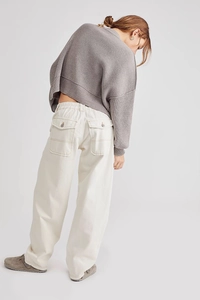 Dettaglio dei pantaloni cargo bianco sporco con cuciture a contrasto e tasche