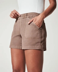 Detail view of khaki high-waisted shorts featuring large cargo pockets and contrast stitching