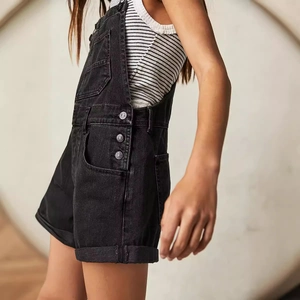 Salopette en jean noir pour femme, coupe ample avec poches et boutons latéraux