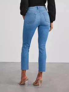 Fashionable high-waisted slim fit stretch denim jeans with raw hem and light blue wash