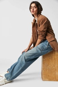 Dettaglio dei jeans a vita alta abbinati a un blazer marrone a righe verticali