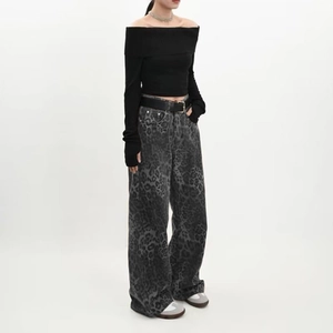 Détail d'un jean large gris à imprimé léopard avec une ceinture en cuir noir chic
