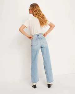 Detail view of high waist light blue straight-leg jeans with back pockets and a relaxed fit