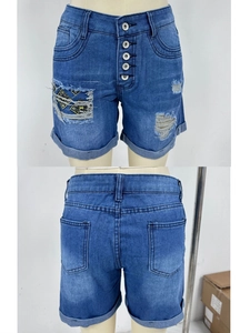 Détail d'un short en jean taille haute avec boutons en métal et écussons en tissu jaune