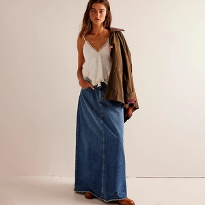 Macro detail of dark blue denim maxi skirt with natural frayed hem and heavy fabric texture