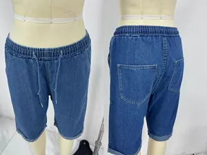Detail view of denim shorts featuring elastic drawstring waist and cuffed hem details