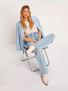 Women's light blue straight-leg ripped jeans paired with a matching blazer and boots