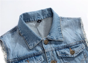 Détail d'un gilet en jean bleu clair montrant des boutons en métal et des bords effilochés