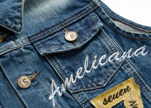 Dettaglio del gilet di jeans blu scuro con ricamo Americana e applicazione Seven