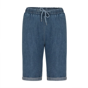 Detailed view of elastic drawstring waist and cuffed hem on dark blue denim shorts