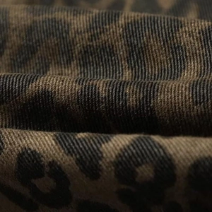 Détail du tissu denim imprimé léopard avec une texture sergé de style rétro