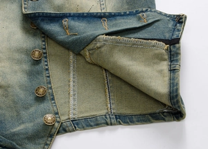 Close-up of vintage washed denim vest with metallic JEANS buttons and reinforced stitching
