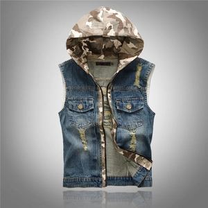 Detail of blue distressed denim vest featuring a camouflage hood and dual chest pockets