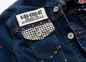 Macro detail of dark blue denim jacket with plaid pocket flap and metal studs decor
