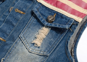 Gros plan sur un gilet en jean bleu avec patchwork à rayures rouges et blanches et détails usés