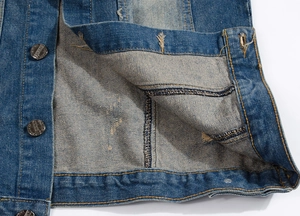 Détail d'une veste en jean indigo montrant le coton épais et les boutons en métal